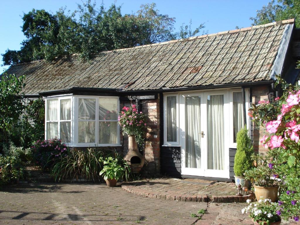 a small house with flowers in front of it at The Blue Cow in Fenstanton