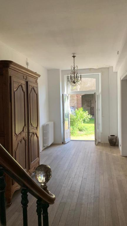 Il comprend un salon doté d'un lustre et de parquet. dans l'établissement Grand corps de ferme à la rue Messire Etienne 89113 Neuilly Valravillon, à Neuilly