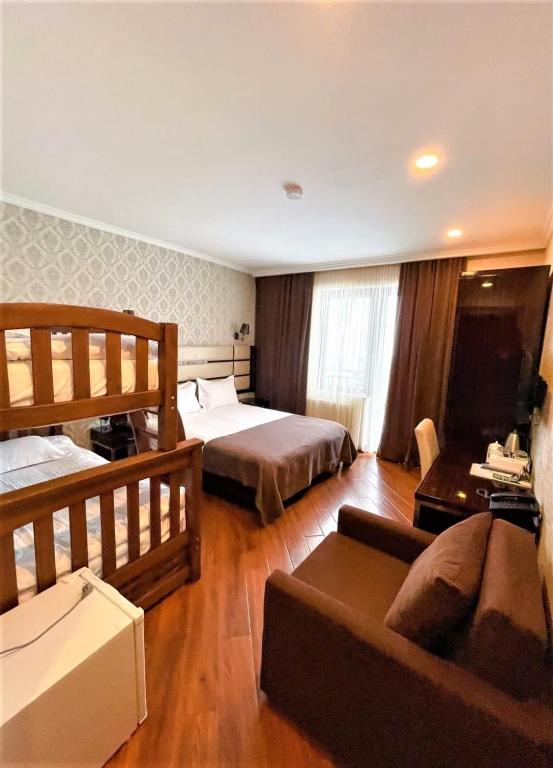 una camera d'albergo con due letti e un divano di Hotel King David Bakuriani a Bakuriani