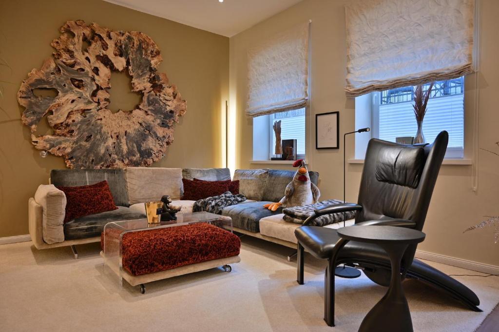 a living room with a couch and a chair at Ferienwohnung PRACHTSTÜCK in Flensburg