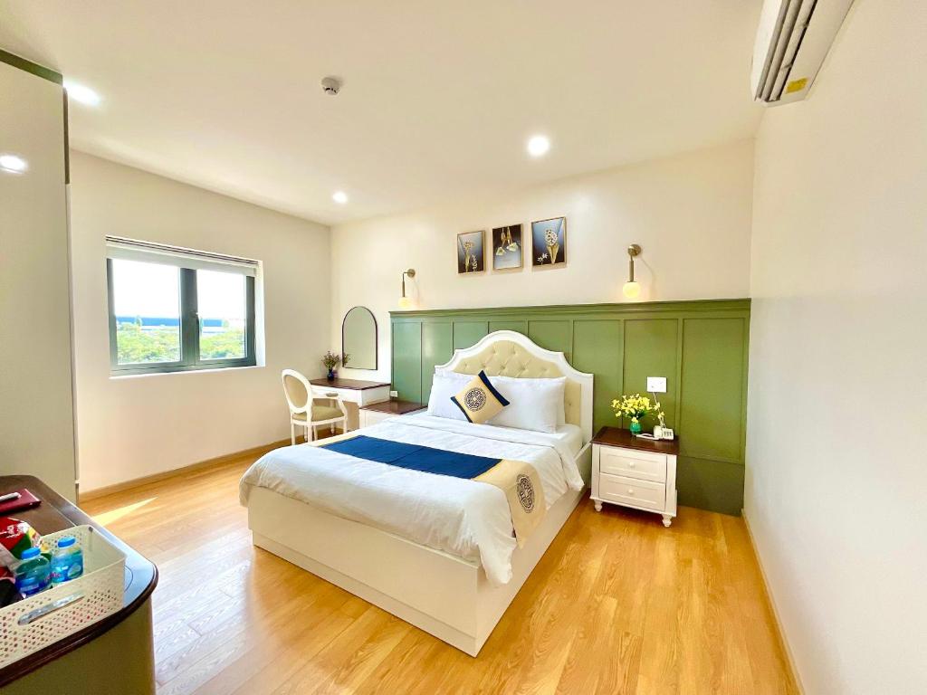 a bedroom with a large bed and a desk at Khải Hoàn Hotel 2 in Bến Cát