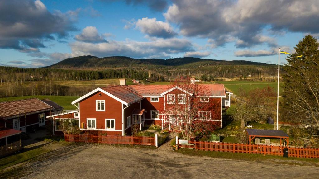 une maison avec une maison rouge et une clôture dans l'établissement Chinova Mötesgård i Järvsö, à Järvsö