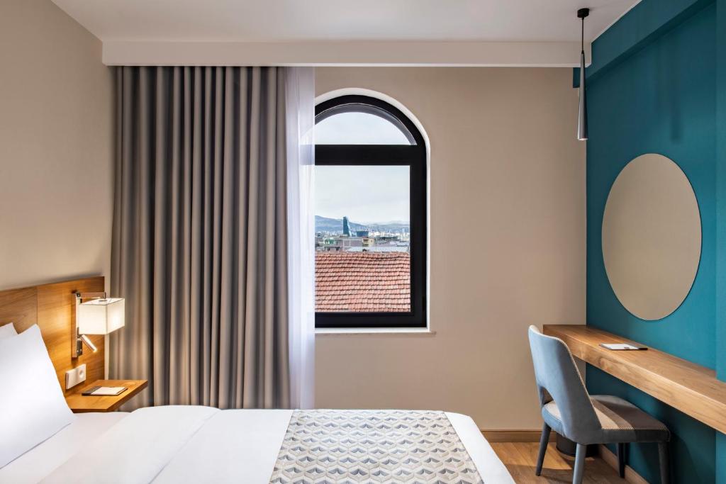 Postel nebo postele na pokoji v ubytování Clocks Hotel Tbilisi