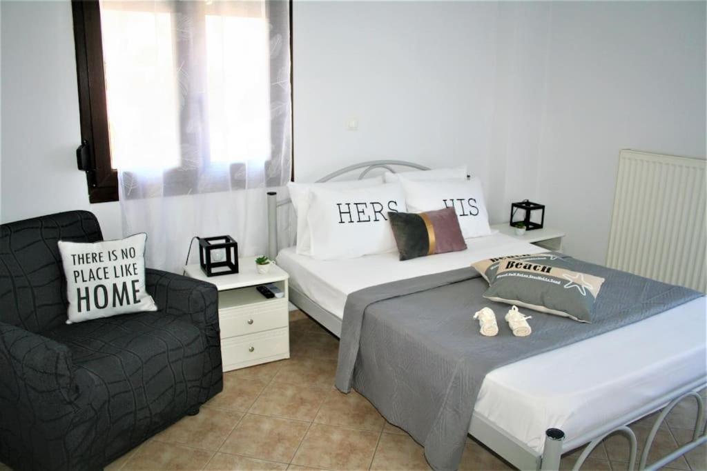 a bedroom with two beds and a chair at Moschoula Villa - Apartment 1 in Limenas