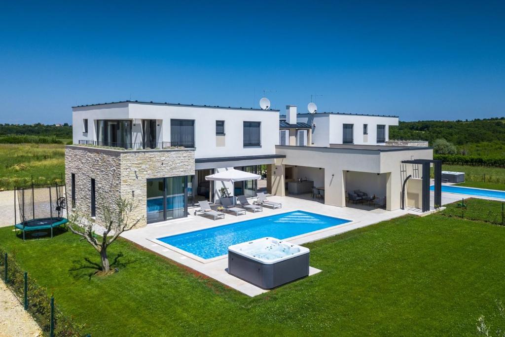 a large white house with a swimming pool at Villa Bella by SeeAdria Agency in Brtonigla