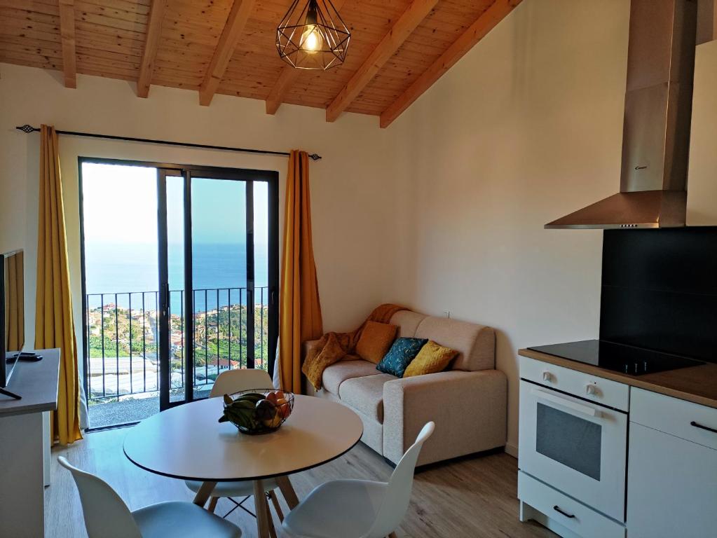 a living room with a table and a couch at Ponta do Sol Private Apartment Sea View in Ponta do Sol