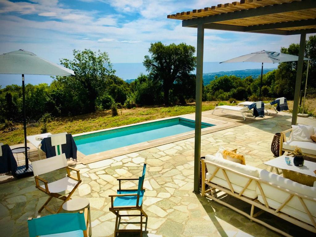 patio z krzesłami i basenem w obiekcie Villa Poggio w mieście Santa-Maria-Poggio