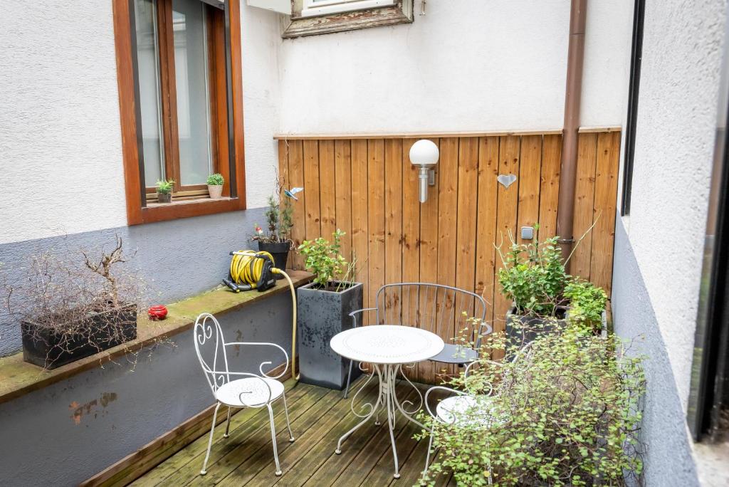 un patio avec deux tables et des chaises sur une terrasse dans l'établissement Gîtes Schwendi - Quartier Petite Venise, à Colmar