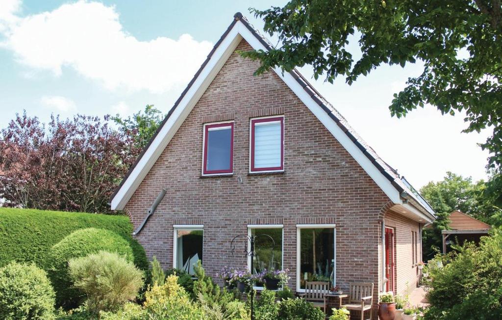 dom z czerwonej cegły z dwoma oknami w obiekcie Heerlijk Egmond w mieście Egmond aan den Hoef
