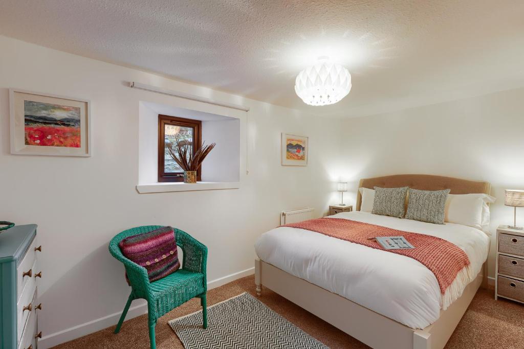 a bedroom with a bed and a chair at Georgian period property w/large enclosed garden in Crieff