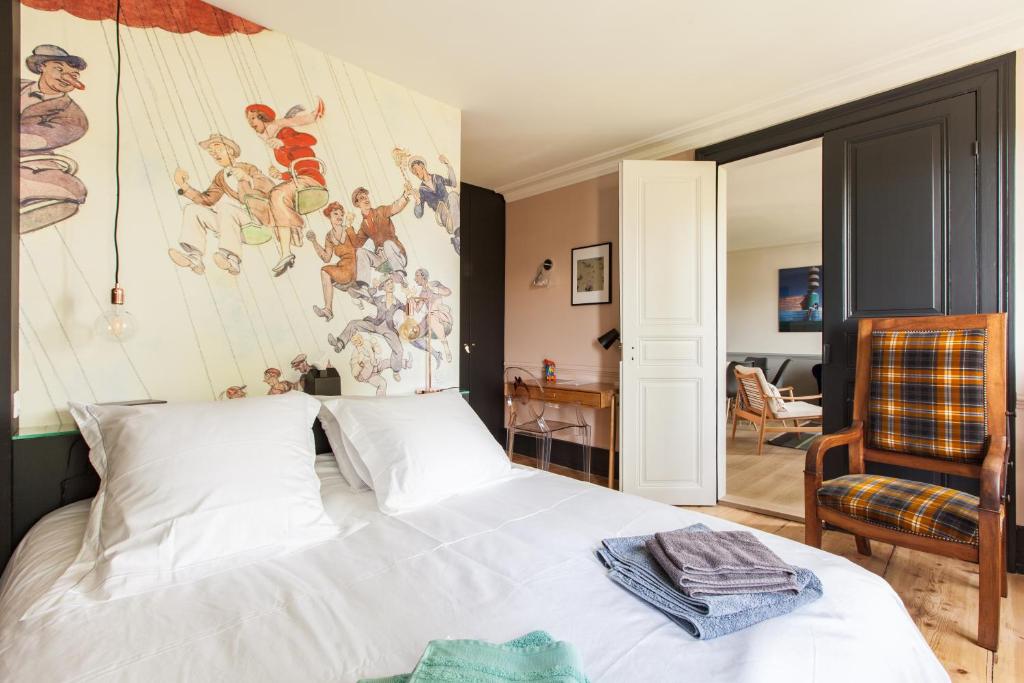 ストラスブールにあるL'Appart du Quai avec Terrasseの白いベッド1台付きのベッドルーム1室(壁に絵画付)
