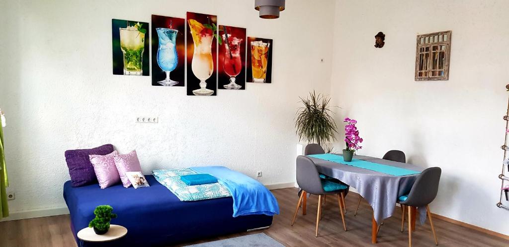 Zimmer mit einem blauen Bett und einem Tisch in der Unterkunft Ferienwohnung Hesse in Grimma