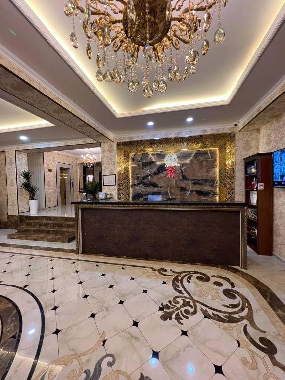 a large lobby with a chandelier and a reception desk at Orient INN Apartment in Tashkent