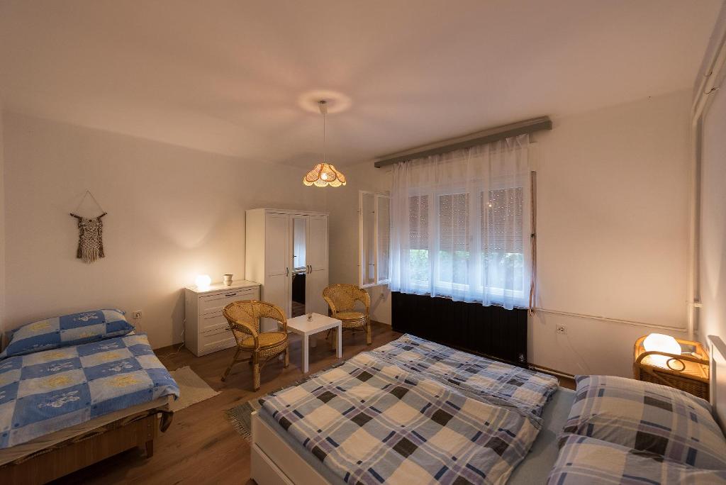 sypialnia z 2 łóżkami, stołem i krzesłami w obiekcie Árnyas Vendégház , Lila akác apartman w mieście Balatonboglár