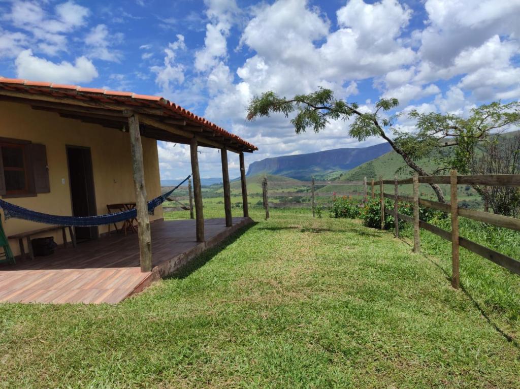 a house with a deck with a view of the mountains at Pousada Velho Chico in Vargem Bonita