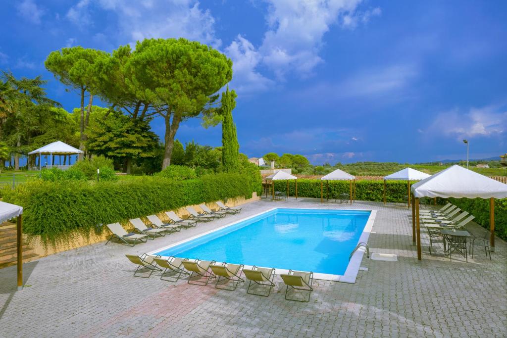 a swimming pool with chairs and umbrellas at Poste del Chiugi in Petrignano sul Lago