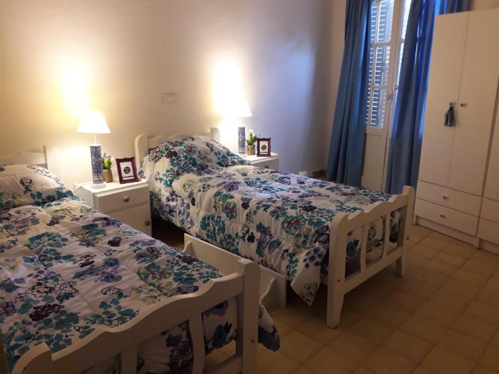 um quarto com 2 camas e 2 candeeiros e cortinas em Rivahome em Córdoba