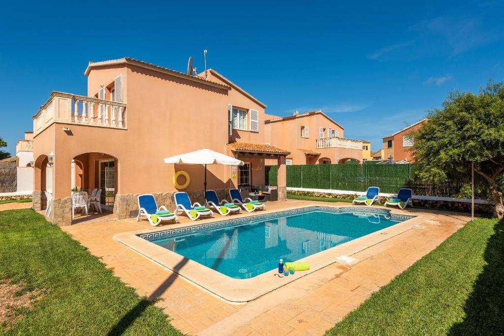 a villa with a swimming pool in front of a house at Villa Llevant in Cala en Blanes