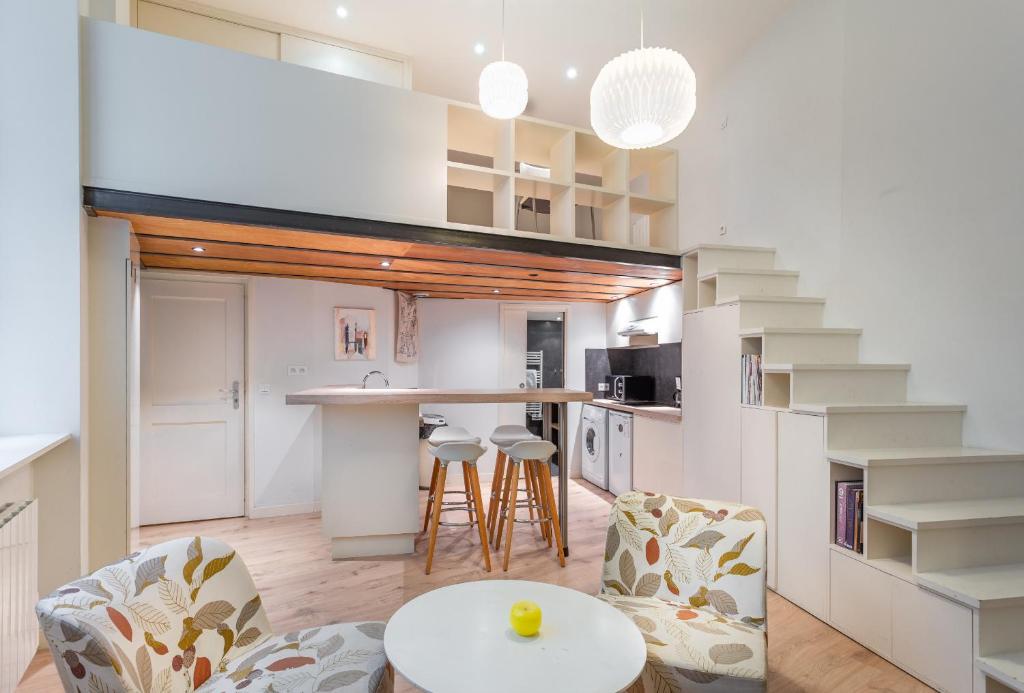 una cocina con escalera, mesa y sillas en DIFY Drevet - Bellecour, en Lyon