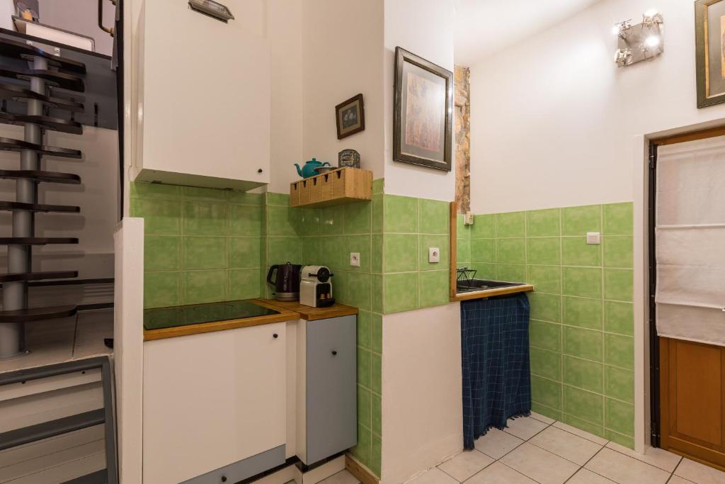 - une cuisine avec du carrelage vert et blanc sur le mur dans l'établissement DIFY Saone - Vieux Lyon, à Lyon