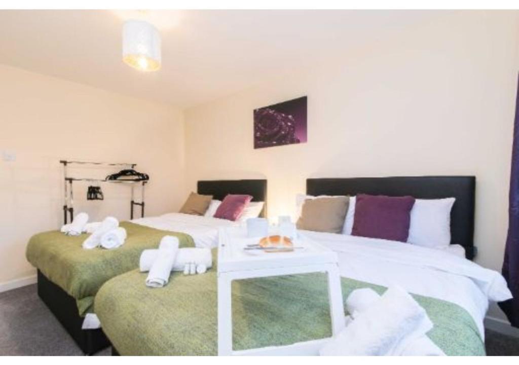 - une chambre avec 2 lits et des serviettes dans l'établissement Sublime Stays Coventry- Jenner Pet Friendly Apartment with Parking, à Coventry