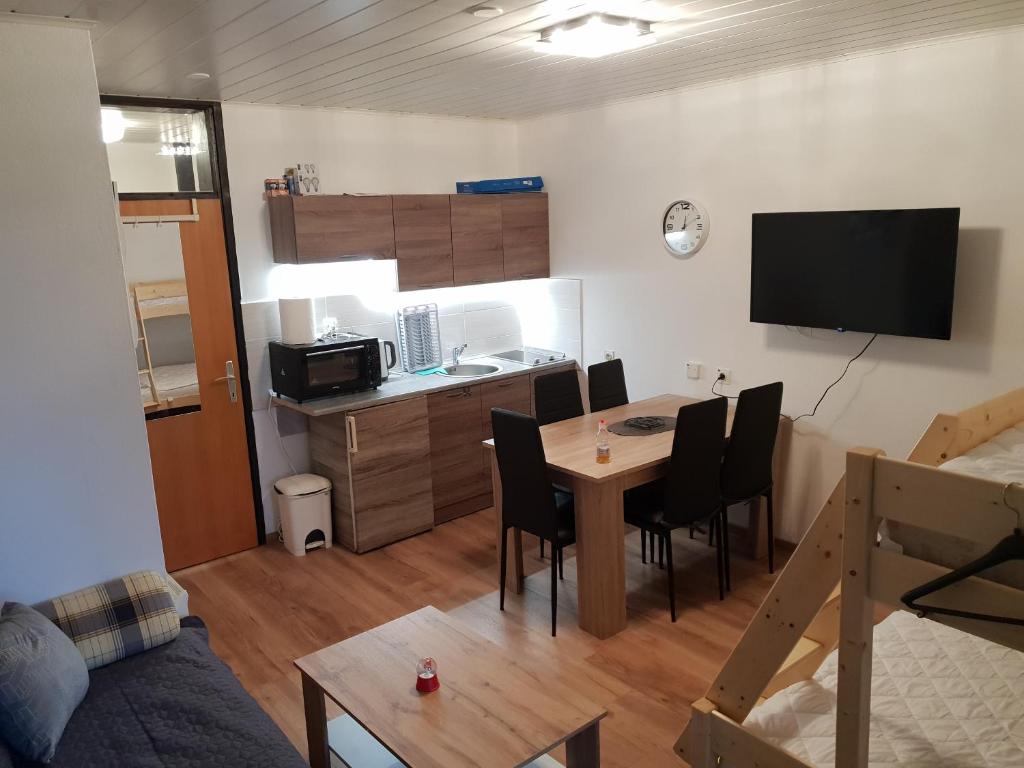 ein Wohnzimmer mit einem Tisch und einer Küche in der Unterkunft Apartma Rogla Gaber 63 in Zreče