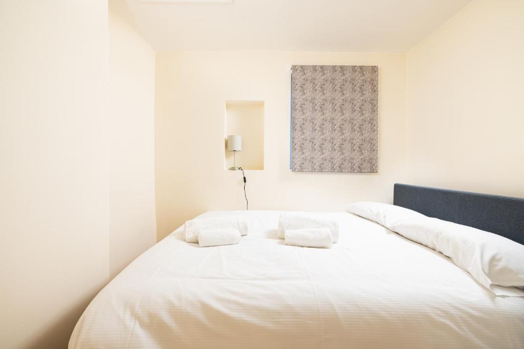 a white bed with two white pillows on it at Charmstay King's Cross in London