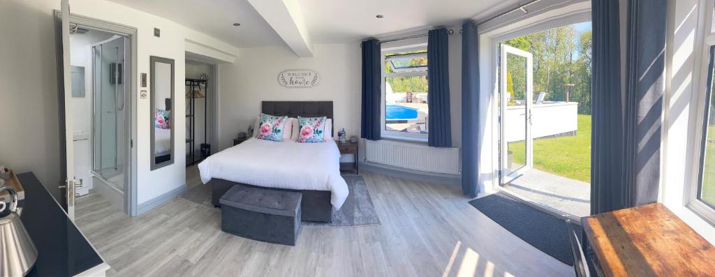 a bedroom with a bed and a large window at Stunning contemporary 1 bedroom En-suite Annexe in Plymouth