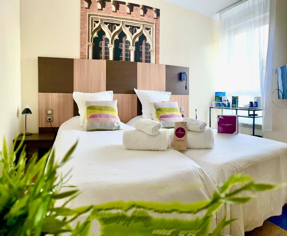 1 dormitorio con 1 cama grande y toallas. en Kyriad Restaurant Centre SPA Vichy, en Vichy