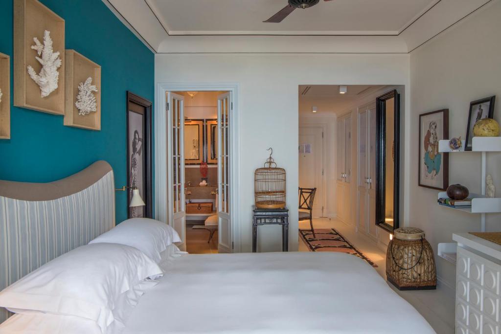 a bedroom with two white beds and a blue wall at Capri Tiberio Palace - The Leading Hotels of the World in Capri