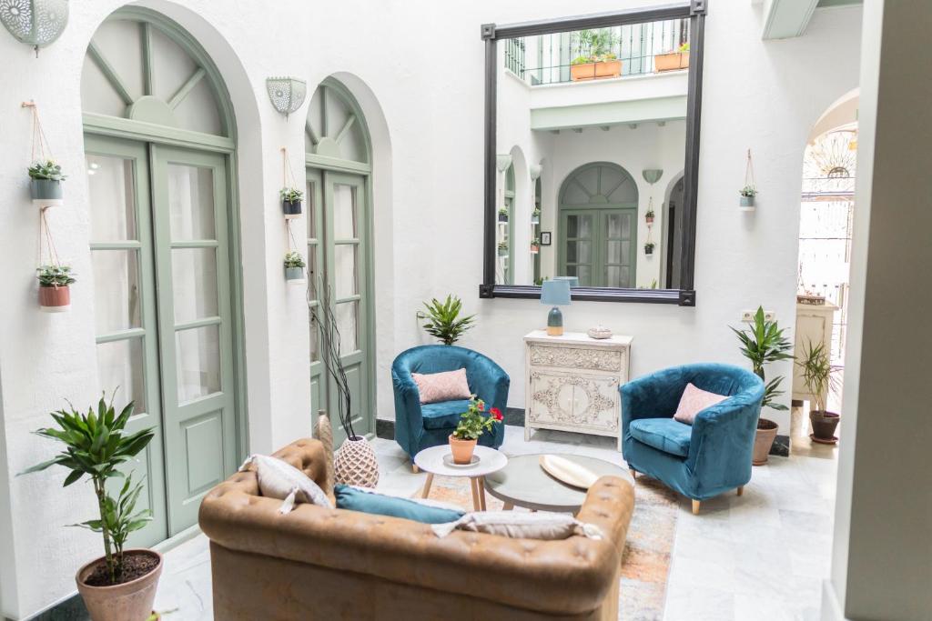 a living room with blue chairs and a table at La Gitanilla Alojamiento & Encanto Jerez in Jerez de la Frontera