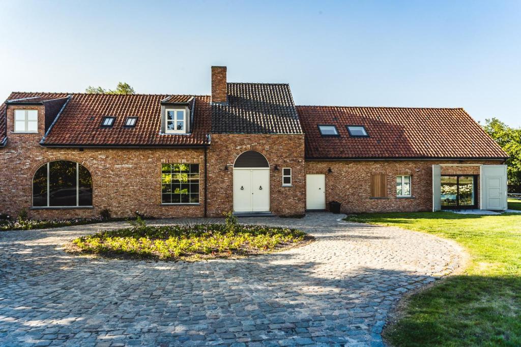 uma casa de tijolos com uma entrada em frente em KOOON em Staden