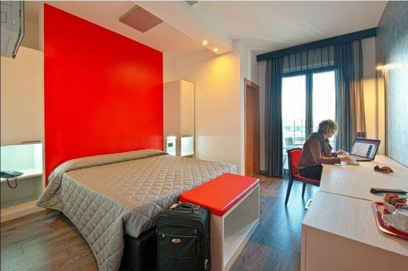 a woman sitting at a desk in a hotel room at Eden Hotel in San Salvo