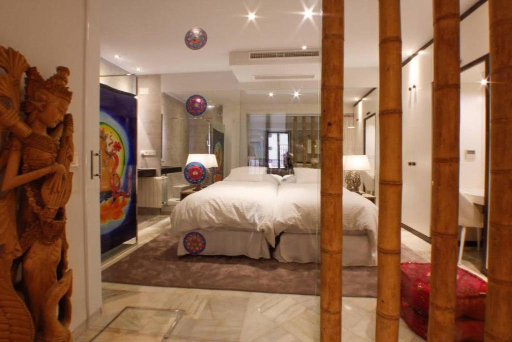 um quarto com uma cama grande e uma casa de banho em Suite Bali em Sevilha