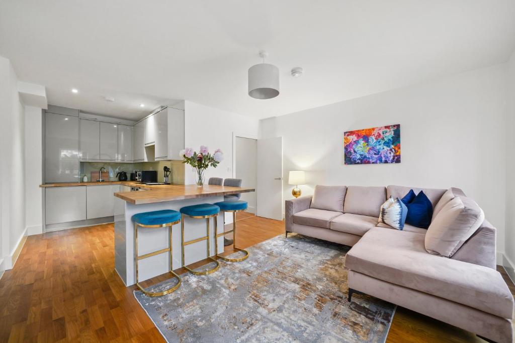 een keuken en een woonkamer met een bank en een tafel bij Hububb - Hyde Park, South Kensington Apartments in Londen