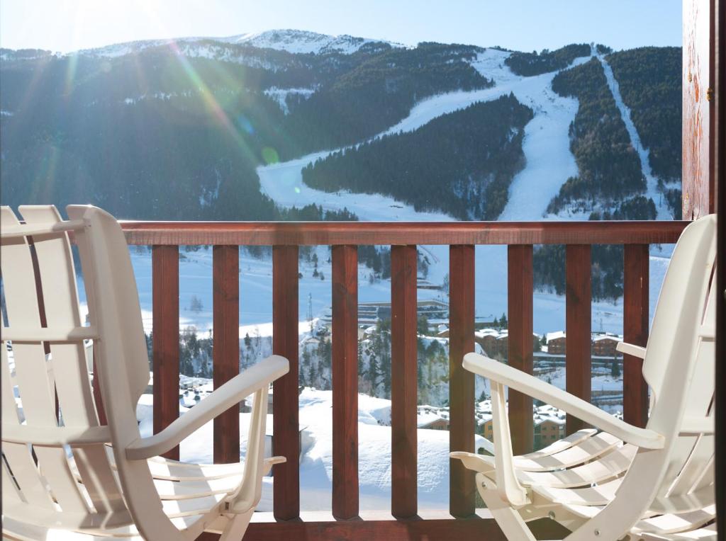 duas cadeiras numa varanda com vista para uma montanha em Apartament Terrasses F em El Tarter