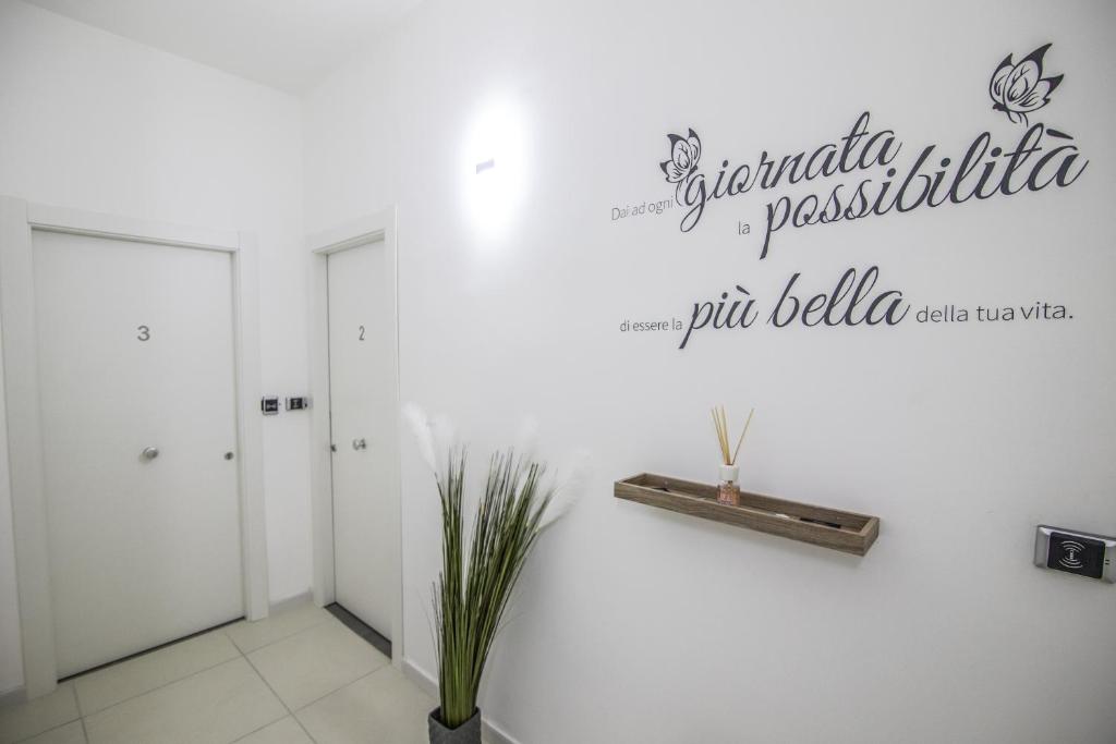 a white room with a sign on the wall at Piano Monaco Apartment in Carini