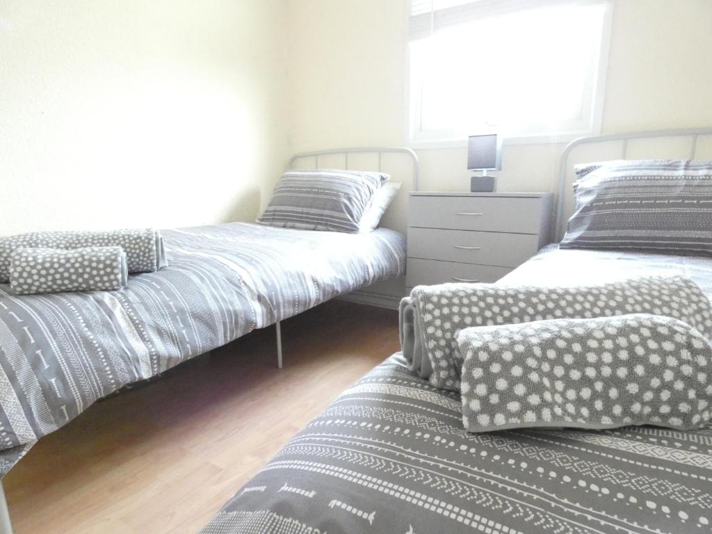 a bedroom with two twin beds and a dresser at Lodge 54 Elmrise Park in Llanstephan