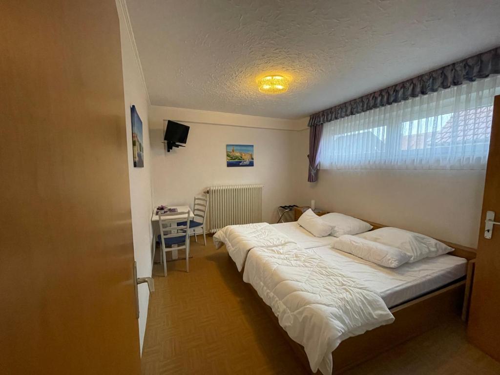 um quarto com uma cama, uma secretária e uma janela em Ferien- & Monteurzimmer Markhausen em Friesoythe