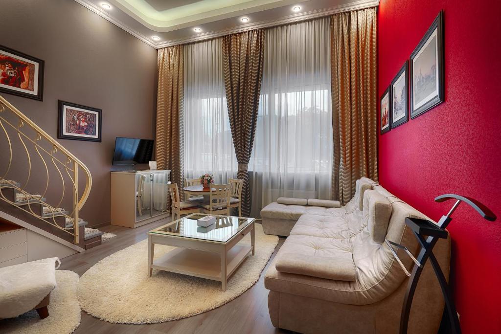 a living room with a couch and a red wall at Tesoro Hotel in Rostov on Don