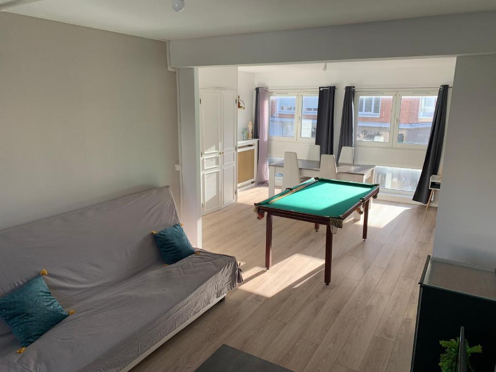 カレーにあるAppartement 65m2 Calais Nord à proximité de la Plageのリビングルーム(ソファ、テーブル付)