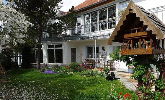 uma casa branca com uma varanda e um quintal em Ferienwohnung Ott Schongau em Schongau