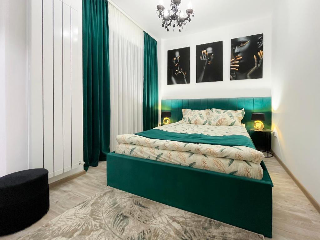 1 dormitorio con 1 cama con cortinas verdes y lámpara de araña en Unique Hotel Apartments Iasi, en Iaşi