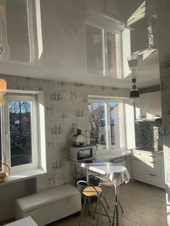 een keuken met witte kasten en een tafel en stoelen bij Home for your vacation 1-bedroom apartment in Narva-Jõesuu