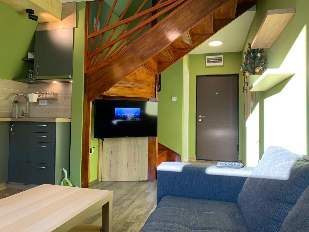 un soggiorno con divano blu e una cucina di G&D Apartment Kopaonik a Kopaonik