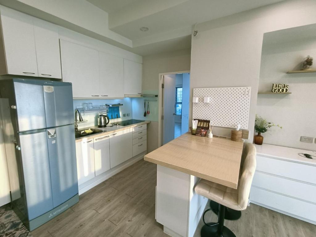 a kitchen with white cabinets and a blue refrigerator at 溫馨小屋 in Bangkok