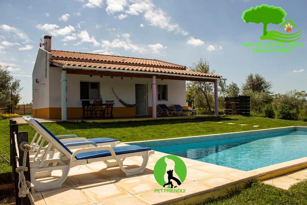 a villa with a pool in front of a house at Monte Quinta Verde in Ferreira do Alentejo