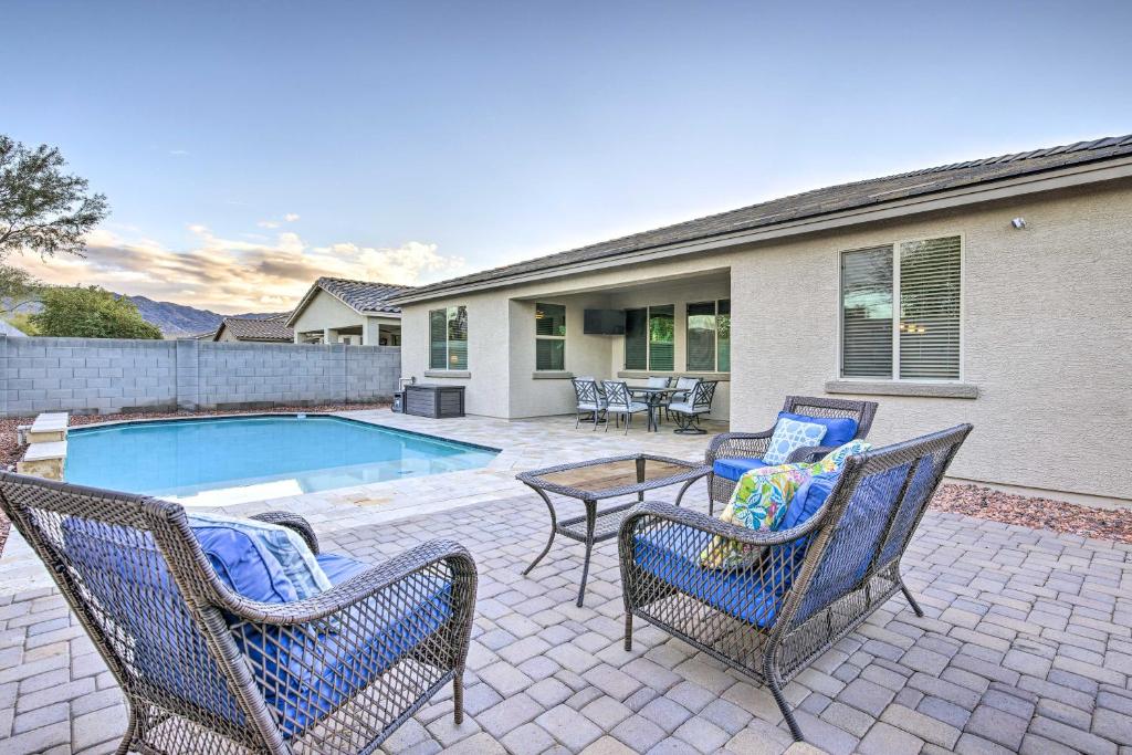 a patio with chairs and a table next to a pool at Phoenix Home with Heated Pool 7 Mi to Downtown! in Phoenix