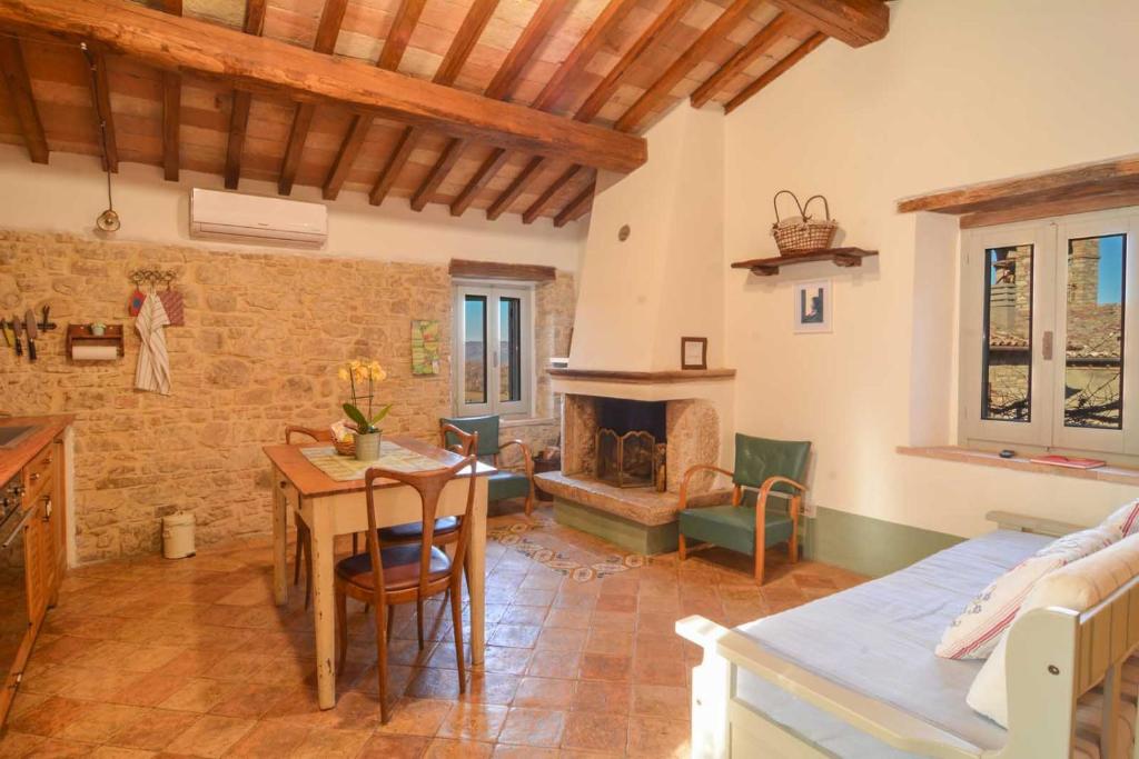 a living room with a table and a fireplace at La casina del vicolo in Collelungo