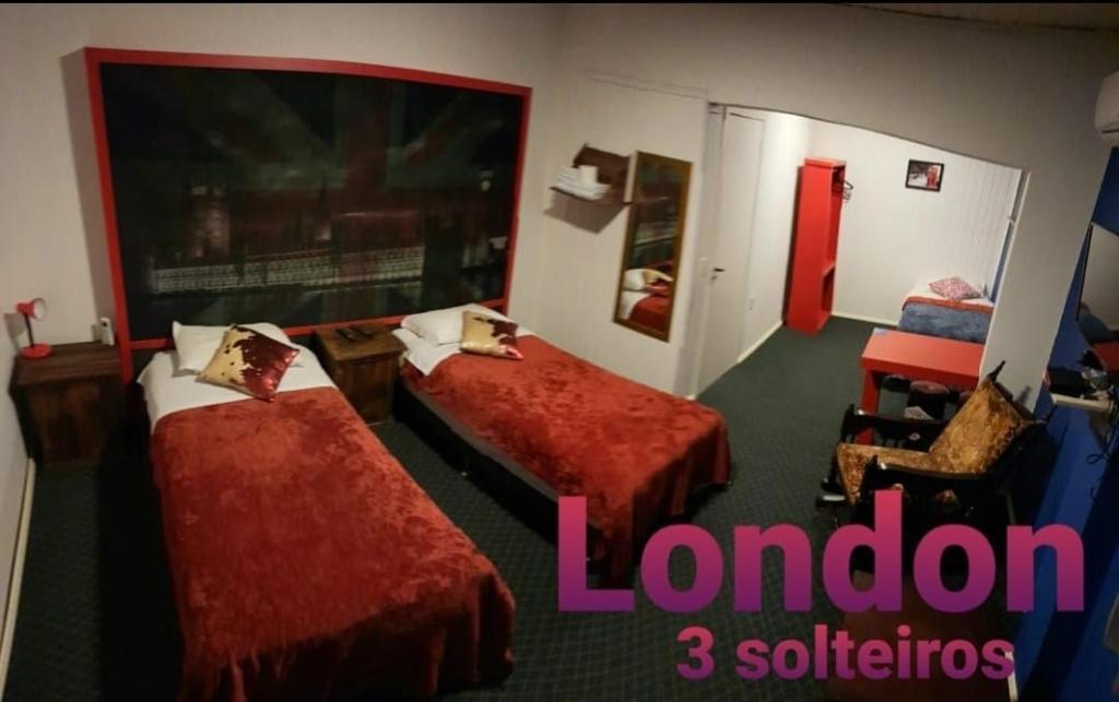 Habitación de hotel con 2 camas con colchas rojas en Pousada Serra Azul, en Urubici